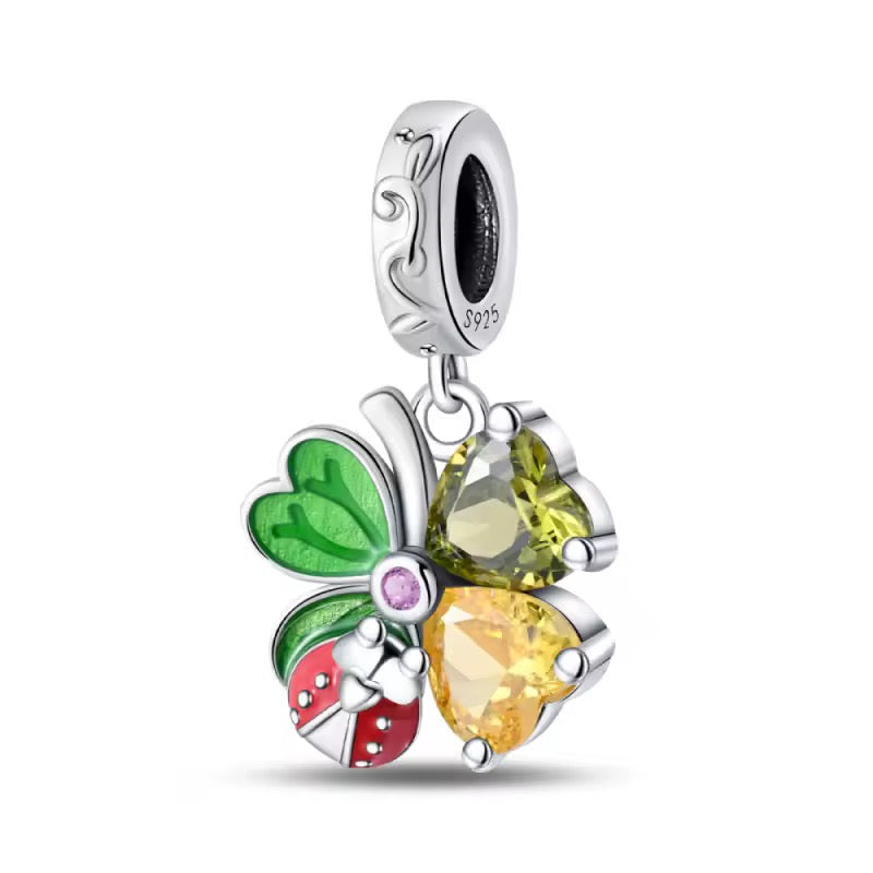 Sterling silver clover charm with green enamel leaves, heart crystals, and red ladybug detail
