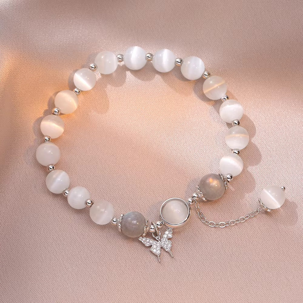 White cat eye beaded bracelet with rhinestone crystal butterfly charm, grey iridescent beads and silver accents