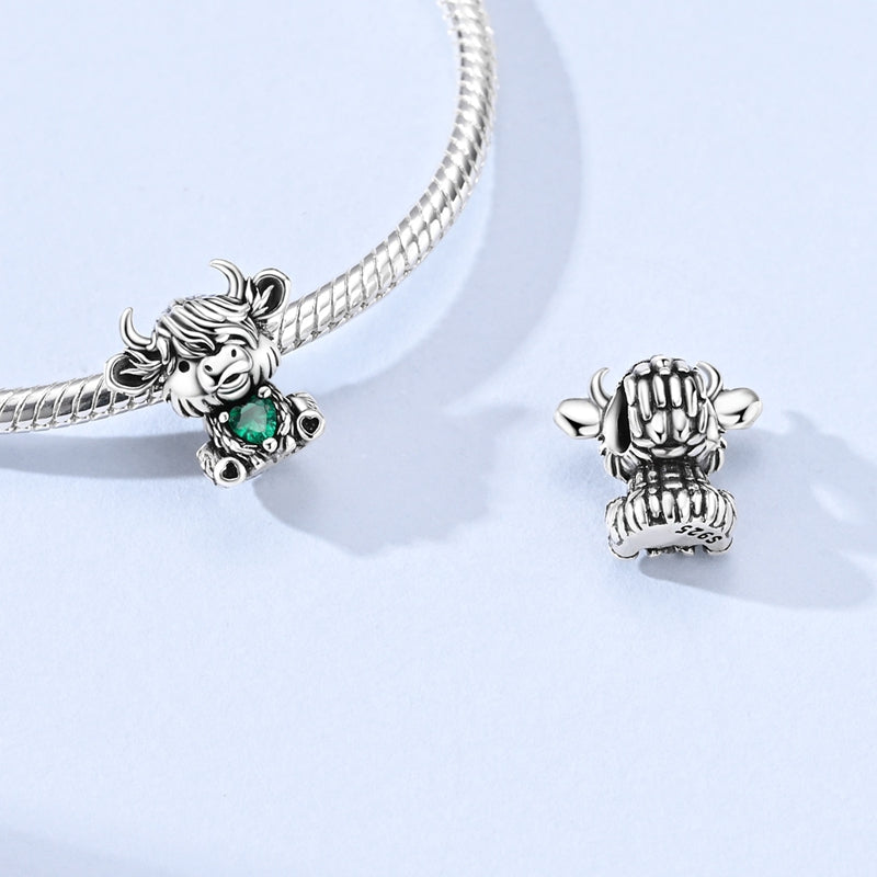 Silver Highland cow charm with emerald green heart crystal and detailed fur design