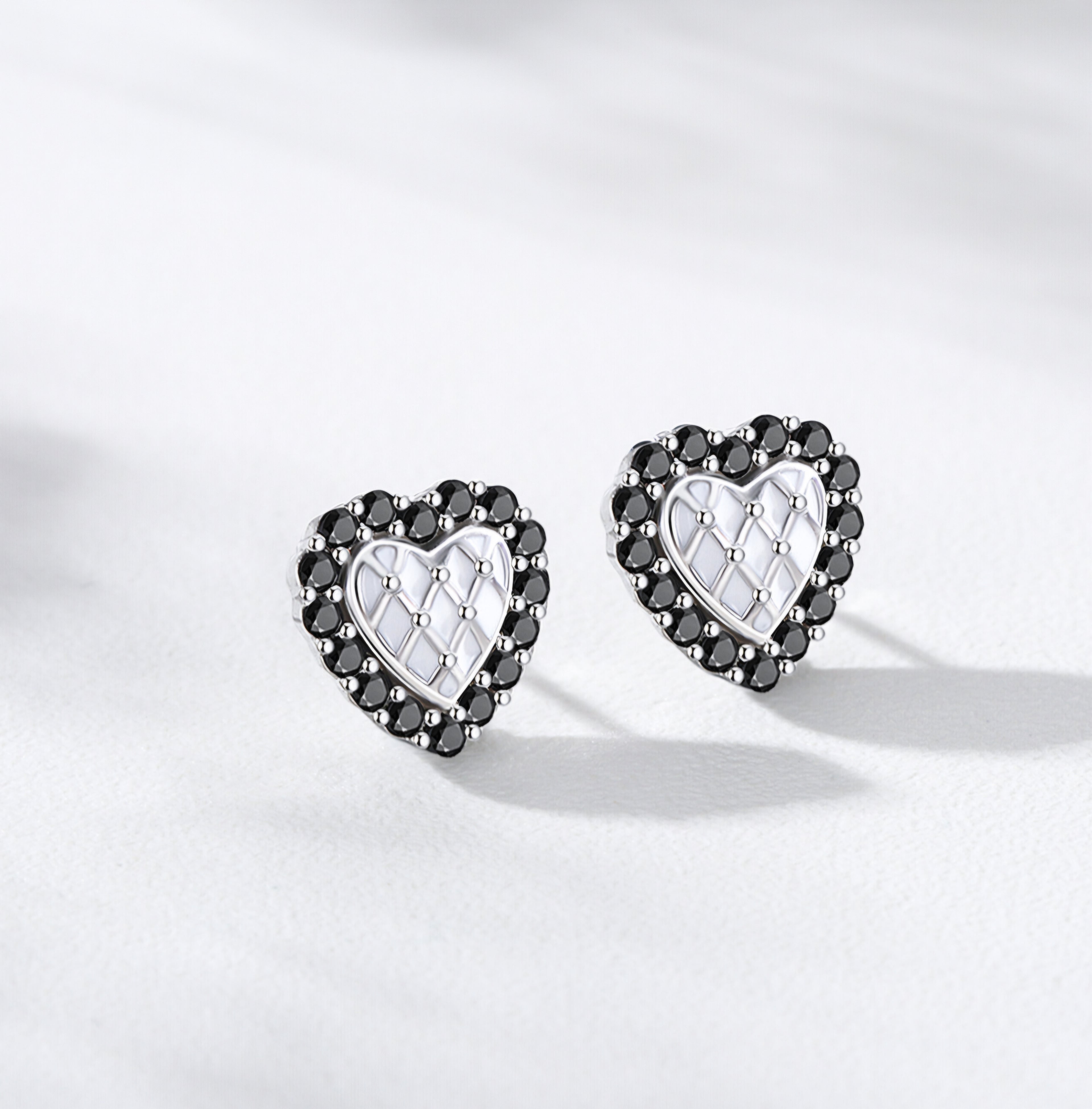 Silver heart stud earrings with black crystal border and white quilted center