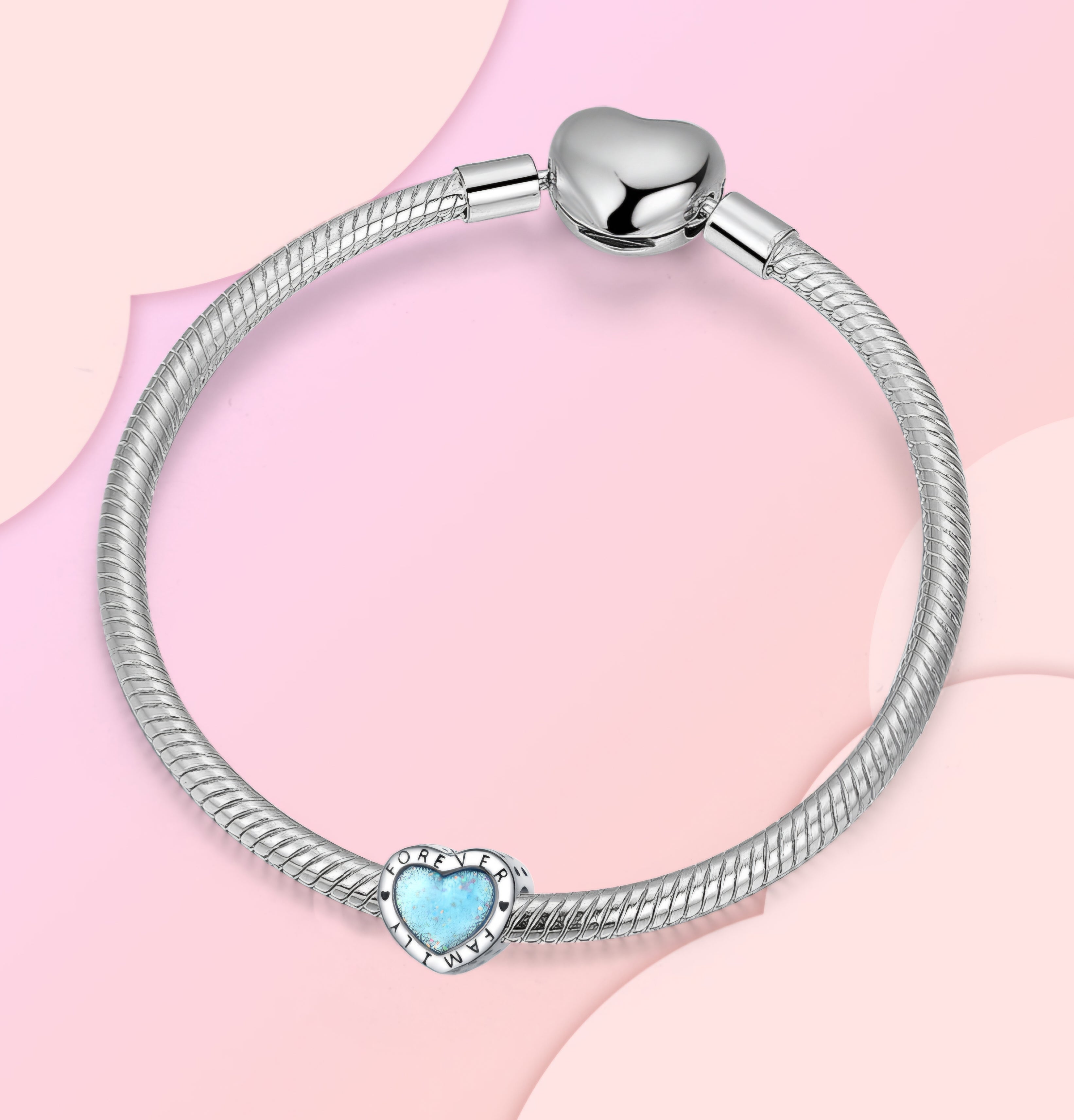 Silver heart charm with blue glitter center engraved with Forever Family and small heart details