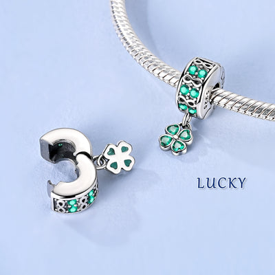 Silver clip-on charm with green crystals, infinity symbols and dangling four-leaf clover
