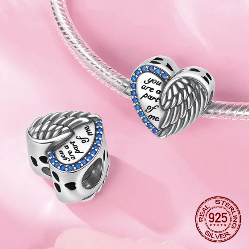 Heart charm with angel wings and blue crystals engraved “You are a part of me”