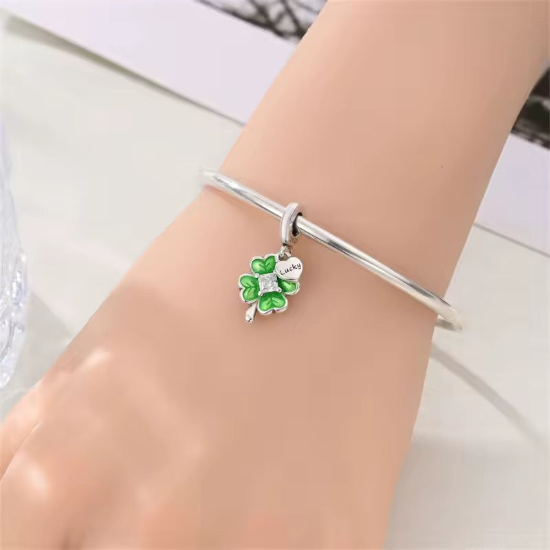 Silver lucky four leaf clover charm with green enamel leaves and crystal center