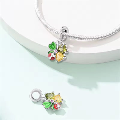 Sterling silver clover charm with green enamel leaves, heart crystals, and red ladybug detail