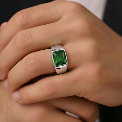 Close-up of a hand wearing a ring with a green gemstone.