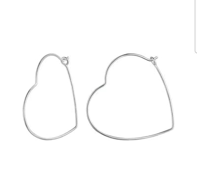 Minimalist heart-shaped hoop earrings in sterling silver worn on ear, thin elegant design