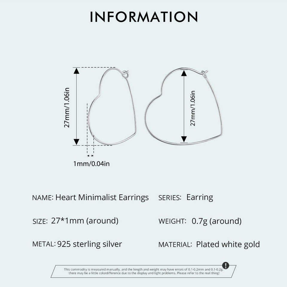 Minimalist heart-shaped hoop earrings in sterling silver worn on ear, thin elegant design