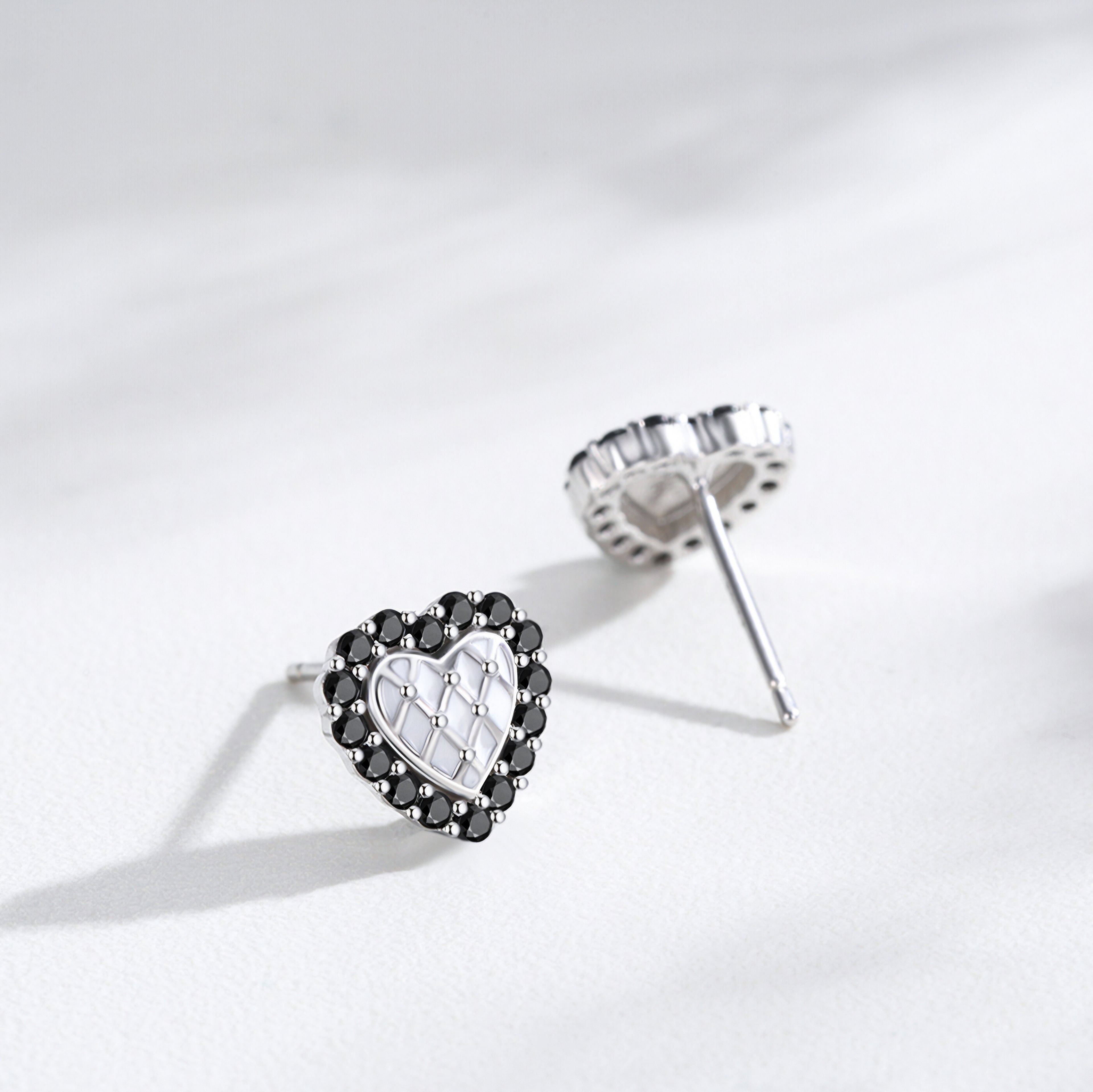 Silver heart stud earrings with black crystal border and white quilted center