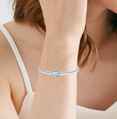 Silver heart charm with blue glitter center engraved with Forever Family and small heart details