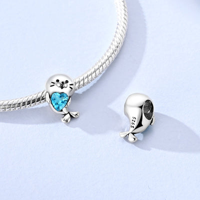 Silver seal charm holding a blue heart crystal pendant