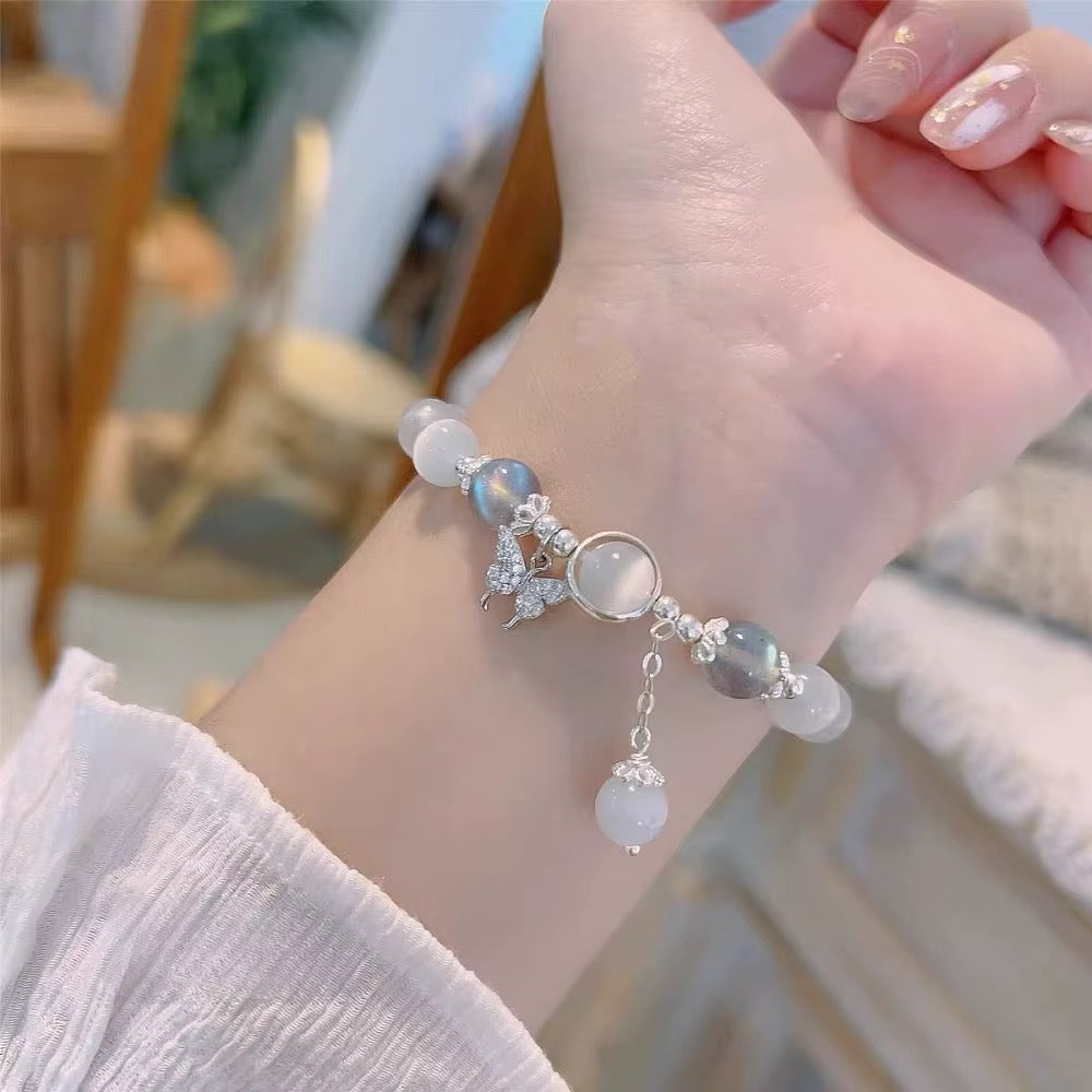 White cat eye beaded bracelet with rhinestone crystal butterfly charm, grey iridescent beads and silver accents
